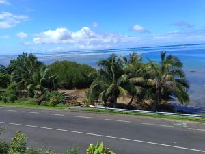 une route bordée de palmiers au bord de l'océan dans l'établissement Tehuarupe Surf Studio 2, à Haapiti