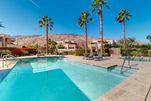 a swimming pool with palm trees in a resort at Thai Palomino in Palm Springs