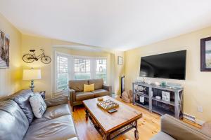 a living room with a couch and a tv at Victorian by the Sea in Oak Bluffs