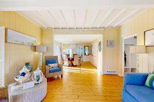 a living room with a blue couch and a chair at Victorian by the Sea in Oak Bluffs