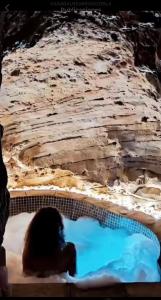 une personne assise dans un bain à remous en face d'une falaise dans l'établissement Casa Balneario Cazorla, à Cazorla