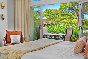 a bedroom with a bed and a patio with a table at Maui Kaanapali Villas A108 in Lahaina +45 photos