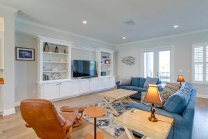 sala de estar con sofá azul y TV en Modern Redington Beach Townhome Steps to Beach!, en St Pete Beach