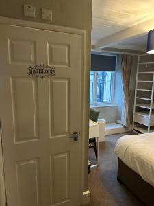 a bedroom with a door leading to a bed and a desk at The kings head in Chacewater