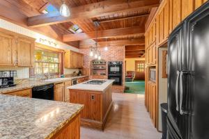 a kitchen with wooden cabinets and a black refrigerator at Glacier-on-Ice in Kalispell