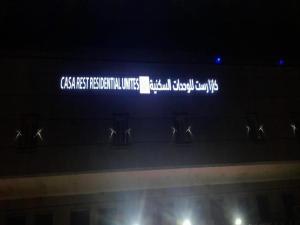 a sign on the side of a building at night at كازا رست للوحدات السكنية in Ḩayy aş Şāliḩīyah