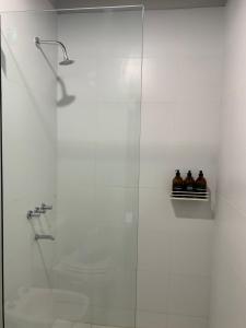 a bathroom with a shower with three bottles on a shelf at Bosques de Mayo Departamento 4 in Maipú +9 photos