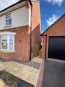 a brick house with a garage at Comfortable 5-Guests Abode - In Quiet Village in Lincolnshire