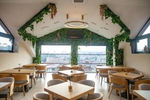 a restaurant with tables and chairs and a large window at Hotel Herc Sarajevo in Sarajevo