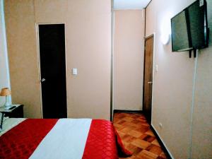 1 dormitorio con 1 cama roja y blanca y TV de pantalla plana en the scandinavian en Valparaíso
