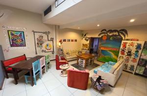 Stray Cat Hostel في سان خوسيه: غرفة معيشة مليئة بالاثاث وطاولة