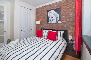a bedroom with a large bed with a brick wall at Modern 3BR Apartment in NYC in New York
