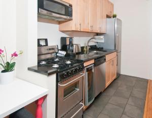 a kitchen with a stainless steel stove top oven at Modern 3BR Apartment in NYC in New York