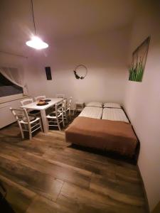 1 dormitorio con 1 cama, mesa y sillas en apartma Vila TARA, en Prebold