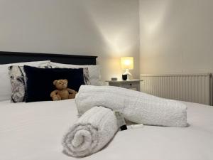 a stuffed teddy bear sitting on top of a bed at Heswall apartment in Wirral