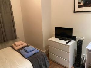 Habitación pequeña con cama y tocador con TV. en Notting Hill Next Door Bedroom in the share flat en Londres