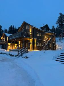 una casa de madera en la nieve por la noche en Modern Stuga med Ski Lodge känsla, en Järvsö