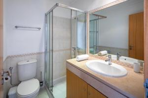 a bathroom with a toilet and a sink and a shower at Appartement Vista das ondas in Olhos de Água +1 photo