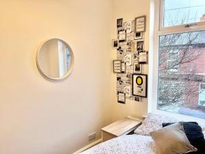 曼徹斯特的住宿－Awesome 4 Bed House in Manchester，一间卧室配有镜子、一张床和一个窗户