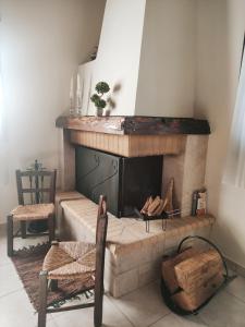 a living room with a fireplace and two chairs at The best spot of Levidi village in Levidi