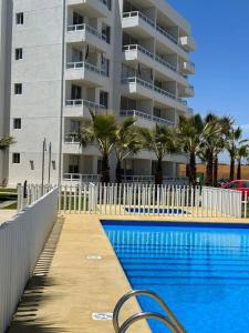 una piscina frente a un gran edificio de apartamentos en Depto nuevo a pasos de la playa, en La Serena