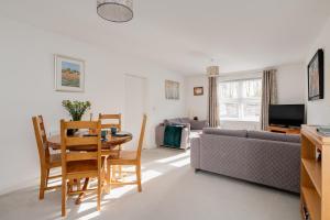 a living room with a table and a couch at Spire View - New Forest Holiday Home in Lyndhurst