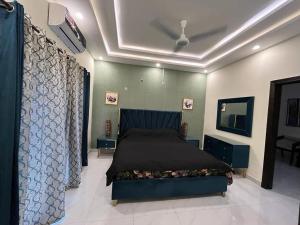 um quarto com uma cama azul num quarto em Vacation Villa em Lahore