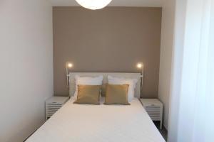 a bedroom with a white bed with two yellow pillows at Gite des Perrines 