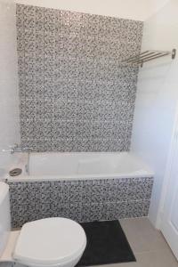 e bagno con servizi igienici bianchi e vasca. di Gite des Perrines a Colombier-le-Cardinal Altre 12 foto