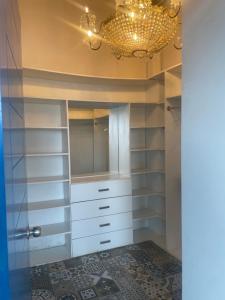 a closet with white cabinets and a chandelier at Miraflores espectacular Loft linda vista in Lima