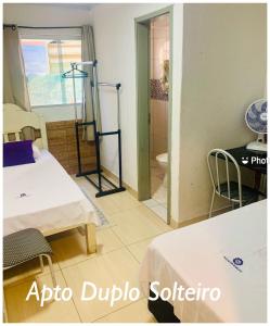 Cette chambre comprend deux lits et une salle de bains pourvue de toilettes. dans l'établissement Pousada Estrela Veadeiros, à Alto Paraíso de Goiás