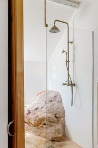 a glass shower in a bathroom with a rock at Casa Brava - Algarve in Loulé