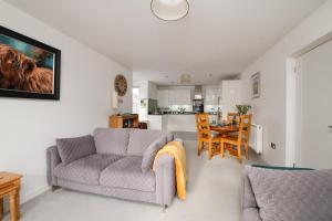 a living room with a couch and a table at Spire View - New Forest Holiday Home in Lyndhurst