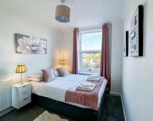 a bedroom with a large bed with a window at 3 Bedroom House - Home away from Home - Sleeps 7 in Portsmouth