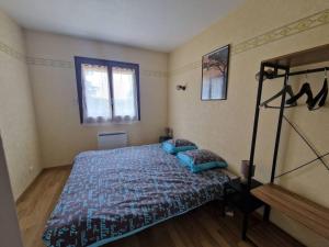 Schlafzimmer mit einem Bett mit blauer Decke in der Unterkunft Maison 3 chambres in Commentry
