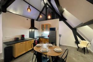 eine Küche mit einem Tisch und Stühlen im Zimmer in der Unterkunft Loft dans chaumière pour 6 personnes à SaintAndré in Saint-André-des-Eaux