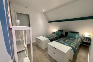 ein Schlafzimmer mit 2 Betten und einer Leiter darin in der Unterkunft Loft dans chaumière pour 6 personnes à SaintAndré in Saint-André-des-Eaux
