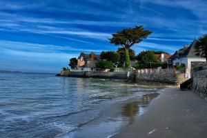- une vue sur la plage avec des maisons et l'océan dans l'établissement Loft dans chaumière pour 6 personnes à SaintAndré, à Saint-André-des-Eaux