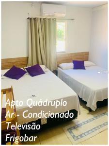 two beds in a room with a window at Pousada Estrela Veadeiros in Alto Paraíso de Goiás