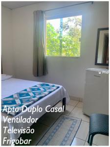 1 dormitorio con cama y ventana en Pousada Estrela Veadeiros, en Alto Paraíso de Goiás