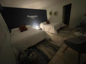two beds in a room with a sign on the wall at Habitación Privada Laureles, Suit Medellin Jacuzzi in Medellín