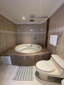 een badkamer met een toilet en een bad bij Habitación Privada Laureles, Suit Medellin Jacuzzi in Medellín