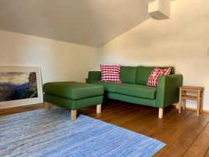 a green couch and a stool in a living room at Haus Widmann in Scheffau am Wilden Kaiser