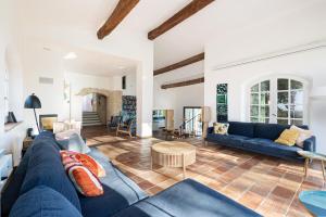 een woonkamer met een blauwe bank en een tafel bij Villa Paloma - nature meets design in Tourrettes-sur-Loup