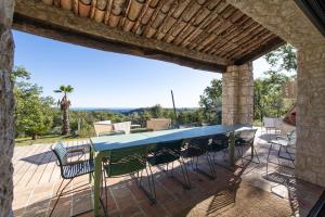 een patio met een blauwe tafel en stoelen bij Villa Paloma - nature meets design in Tourrettes-sur-Loup