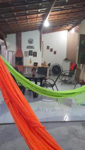 an orange and green hammock in a room with chairs at Hospedaria Temporarte in Piranhas