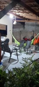 a group of chairs sitting in a patio with a hammock at Hospedaria Temporarte in Piranhas