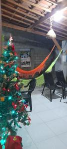 a christmas tree in a room with chairs and a hammock at Hospedaria Temporarte in Piranhas