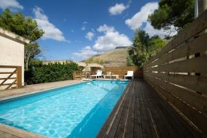 una piscina con una valla de madera junto a una casa en Villa Paradiso, en Castelluzzo