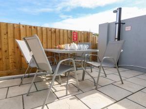 a table and four chairs on a patio at Beach Cottage in Redruth